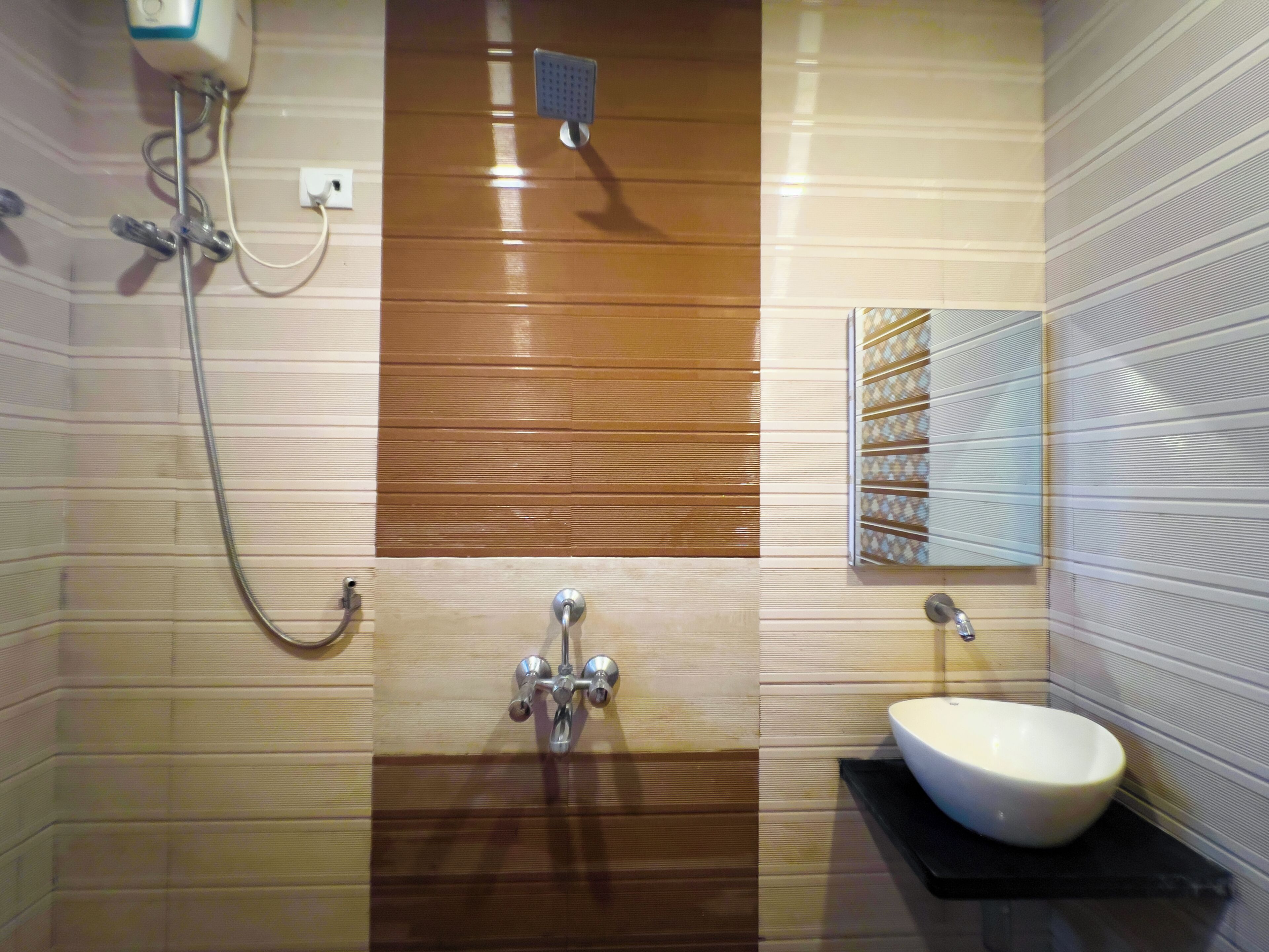 Un baño con lavamanos blanco, ducha y toallero.