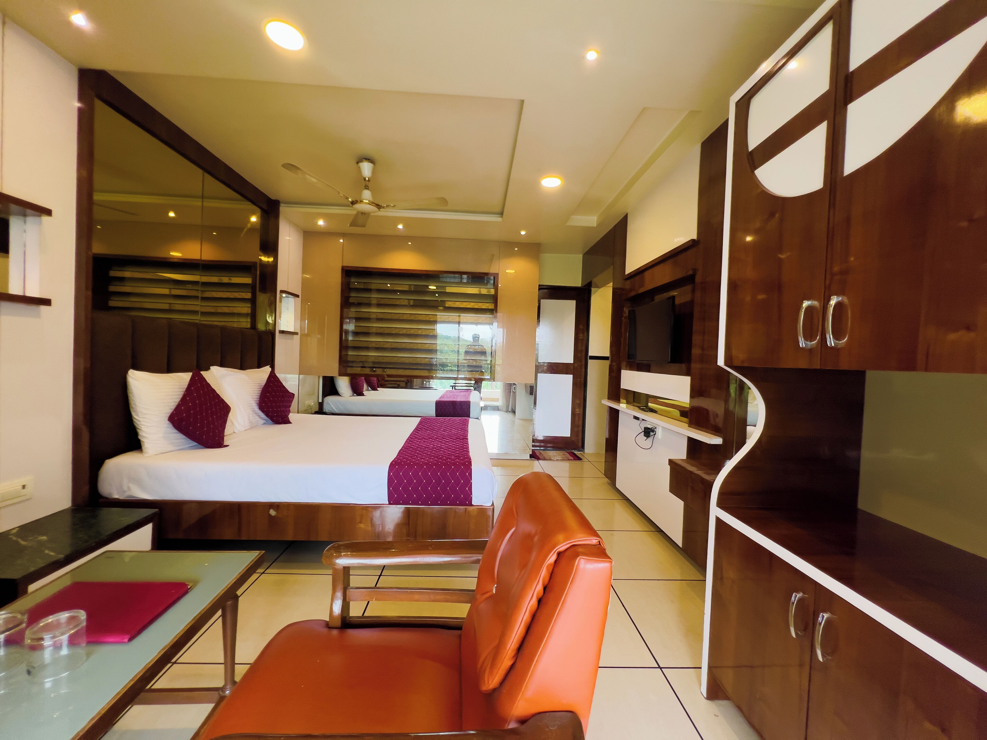 Une chambre d’hôtel comprenant un lit, une télévision, un coin salon et une kitchenette.