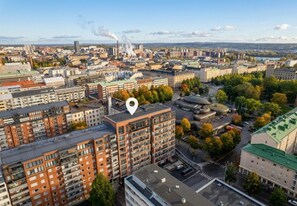 Ein Hochhaus mit mehreren Etagen, umgeben von anderen Gebäuden und Bäumen.