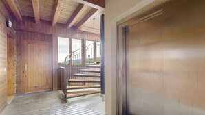 A wooden interior with a staircase, a door, and a view through a window. - Unique Apartment in Font Romeu (Font-Romeu)
