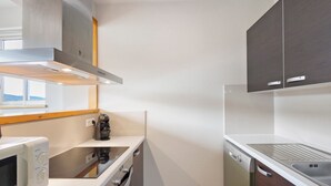 Une cuisine compacte équipée d’un four à micro-ondes, d’une cuisinière et d’un lave-vaisselle.