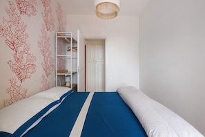 Una camera da letto con un letto, un armadio e una porta che dà su un'altra stanza.