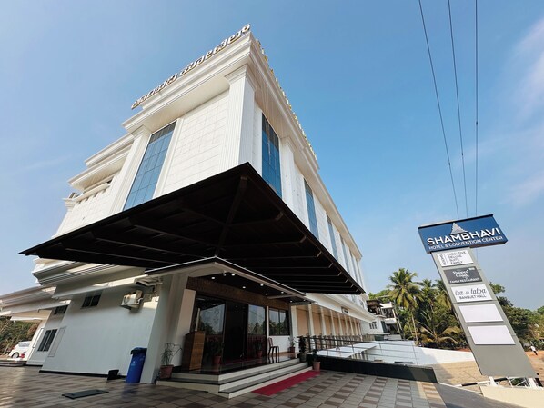 A hotel with a prominent entrance, a covered area, and a sign indicating it is the Shambhavi Hotel & Convention Center. - Shambhavi Hotel & Convention Centre (Udupi)