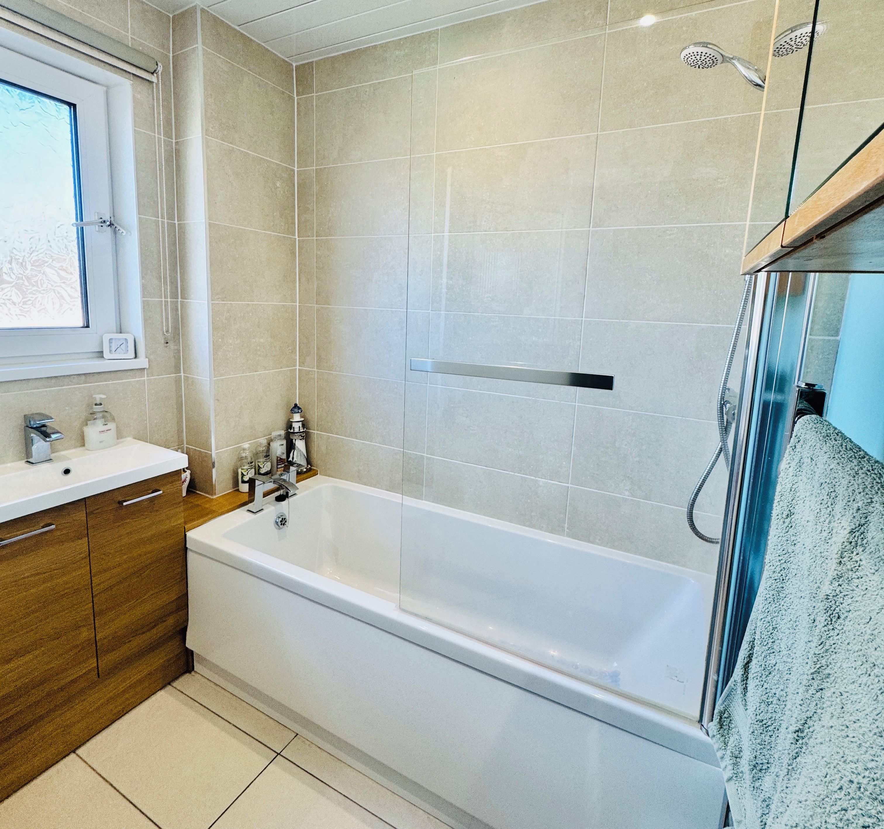 Une salle de bain moderne avec une baignoire, une fenêtre et une douche.