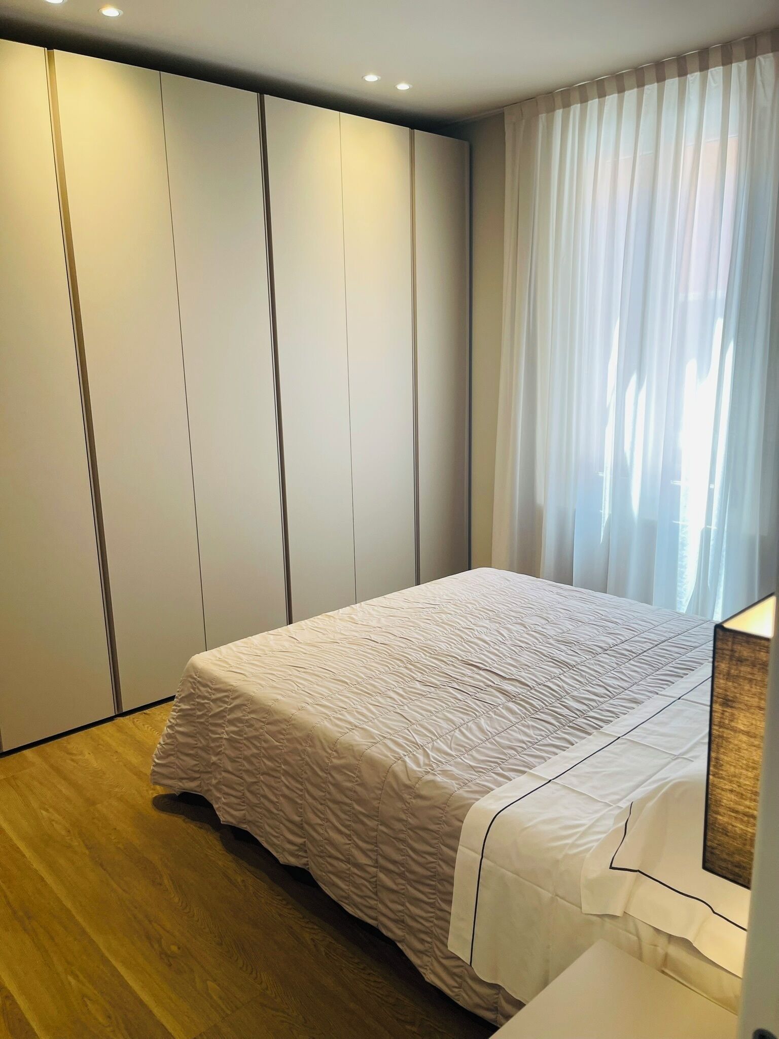 A bedroom with a bed, a wardrobe, and a nightstand.