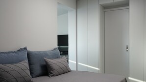 A modern bedroom with a large bed, a flat-screen TV, and a wardrobe. - LOFT WITH PRIVATE TERRACE AND PARTHENON VIEWS (Athina)