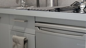 A modern kitchen with a stainless steel sink, a dish rack, and a towel hanging on the door. - LOFT WITH PRIVATE TERRACE AND PARTHENON VIEWS (Athina)
