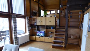 A wooden interior with a TV, seating, and a staircase. - Holiday Home 'Casa Del Diavolo' with Shared Terrace, Balcony and Wi-Fi (Bernau im Schwarzwald)