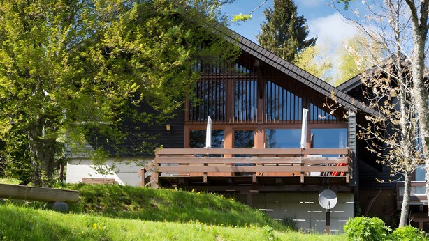 A modern wooden cabin with a balcony, surrounded by lush greenery and trees. - Holiday Home 'Casa Del Diavolo' with Shared Terrace, Balcony and Wi-Fi (Bernau im Schwarzwald)