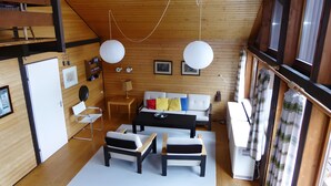 A modern interior with a wooden ceiling, a sofa set, a dining table, and a refrigerator. - Holiday Home 'Casa Del Diavolo' with Shared Terrace, Balcony and Wi-Fi (Bernau im Schwarzwald)