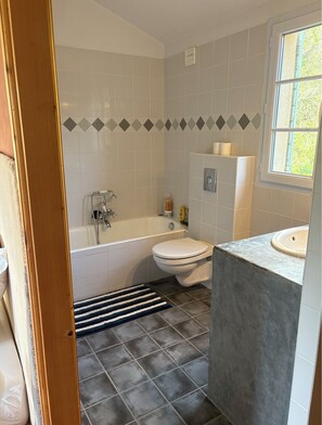 Ein Badezimmer mit Badewanne, Toilette und Waschbecken.