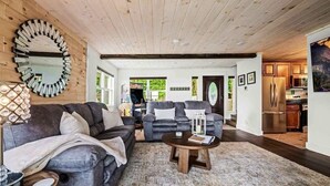A modern living room with a sofa, coffee table, and a large mirror.