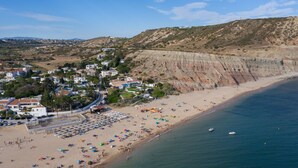 Un pueblo costero con playa, casas y acantilados.