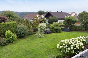 Un quartier résidentiel avec des maisons, une pelouse bien entretenue et divers arbustes et arbres.
