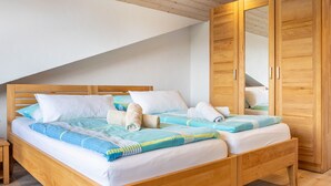 Un lit double avec une tête de lit en bois, une armoire en bois et un miroir.
