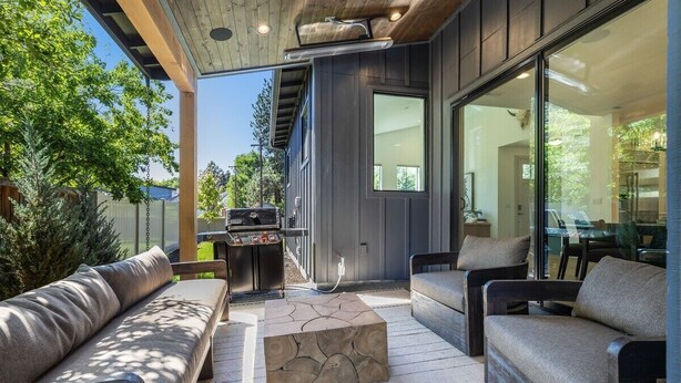 An outdoor living area with a stone coffee table, two sofas, and a grill. - Bluebird Day - Westside Retreat, Discover luxury at a spacious 4-bedroom home in Bend, OR. (Bend)
