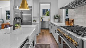 A modern kitchen with stainless steel appliances, white cabinetry, and a central island. - Bluebird Day - Westside Retreat, Discover luxury at a spacious 4-bedroom home in Bend, OR. (Bend)