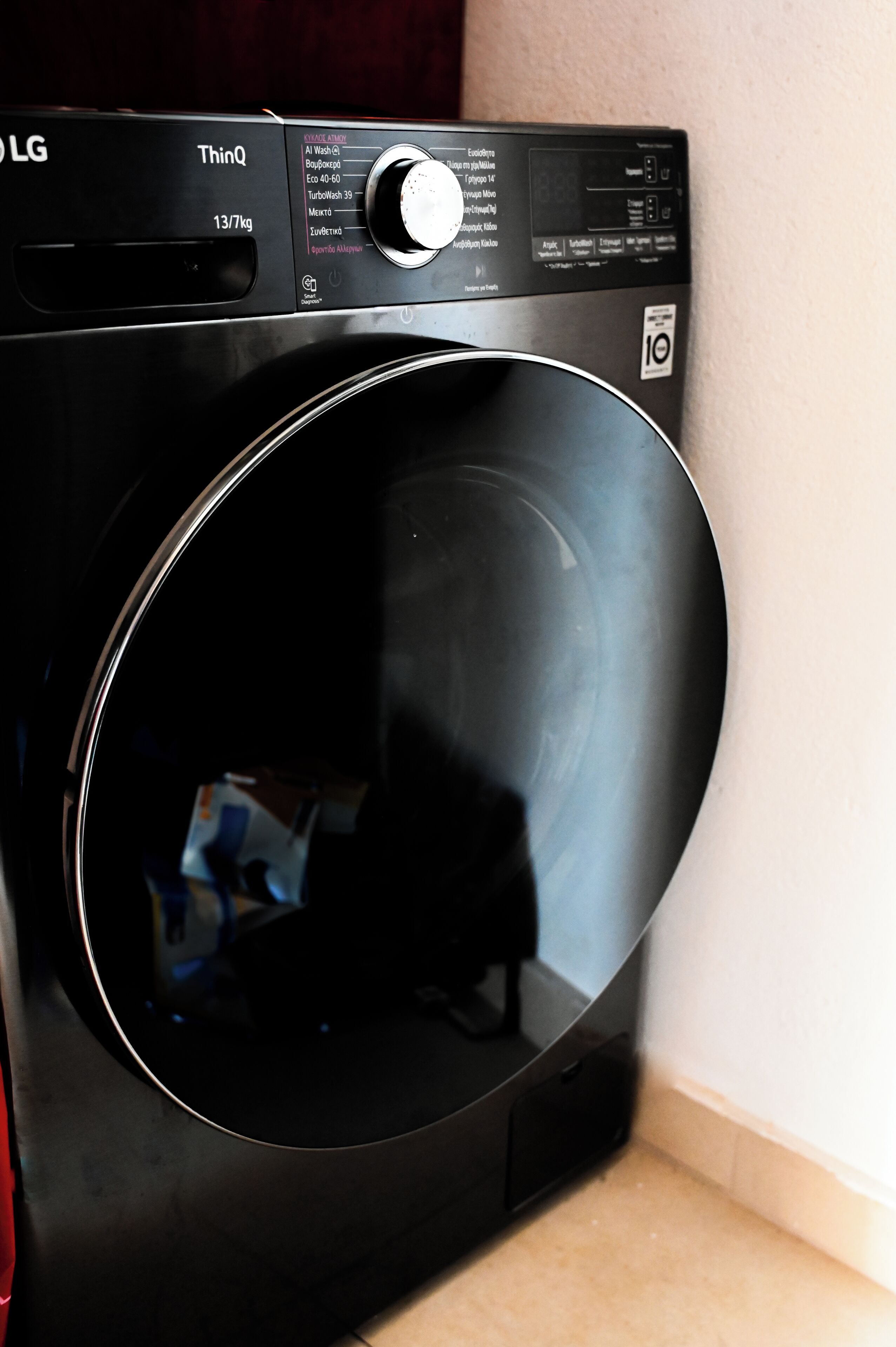 Een zwarte LG wasmachine met een digitaal display en bedieningspaneel.