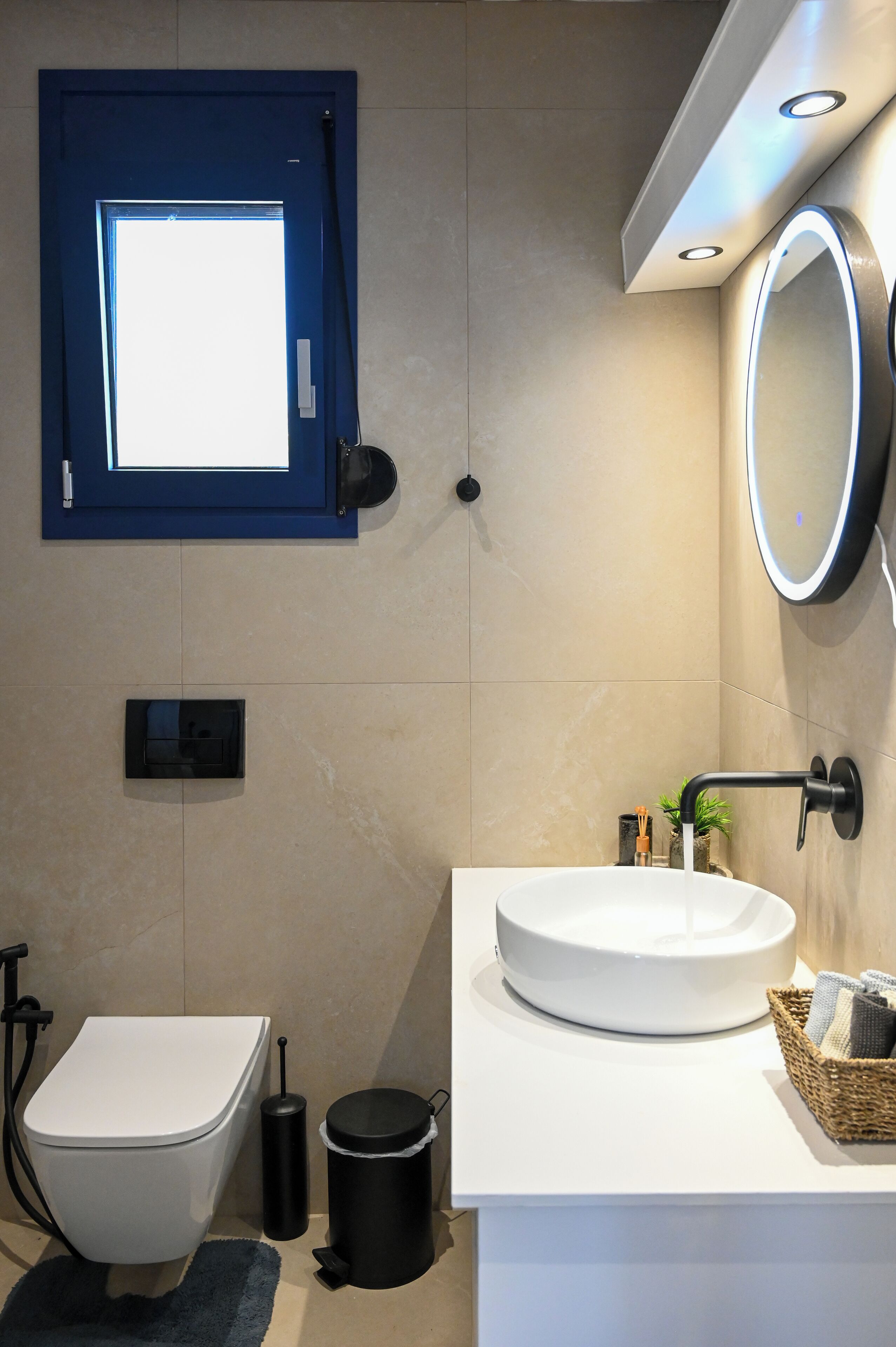 Une salle de bain moderne équipée de toilettes, d’un bidet, d’un lavabo et d’un miroir.