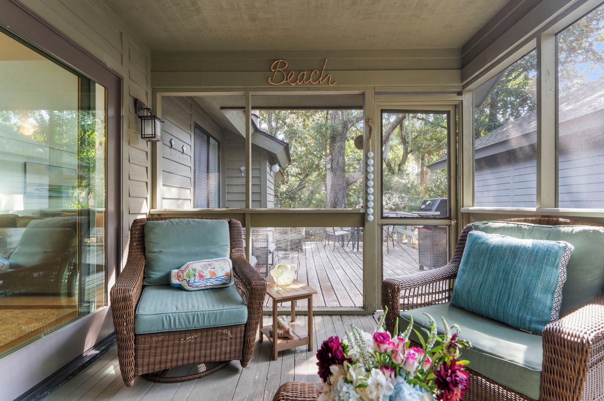 A covered porch with wicker furniture and a 'Beach' sign.