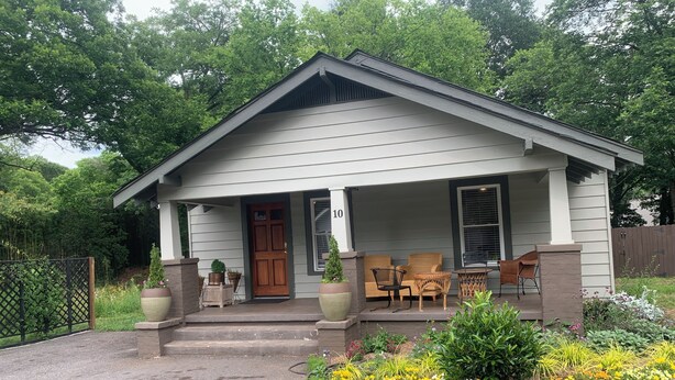 A single-story house with a porch, a front door, and a number '10' sign. - 2:1 Bunkroom Bungalow (Greenville)