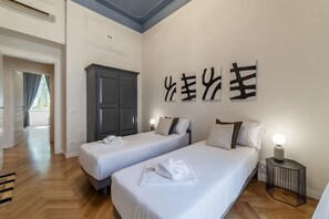 Ein Hotelzimmer mit zwei Betten, einem Kleiderschrank und Bildern an der Wand.