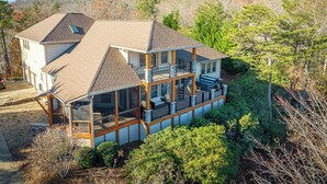 Une maison à deux étages avec un balcon, une véranda et un garage.