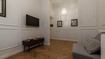 Una sala de estar moderna con un televisor de pantalla plana, un aparador de madera y un sofá gris.