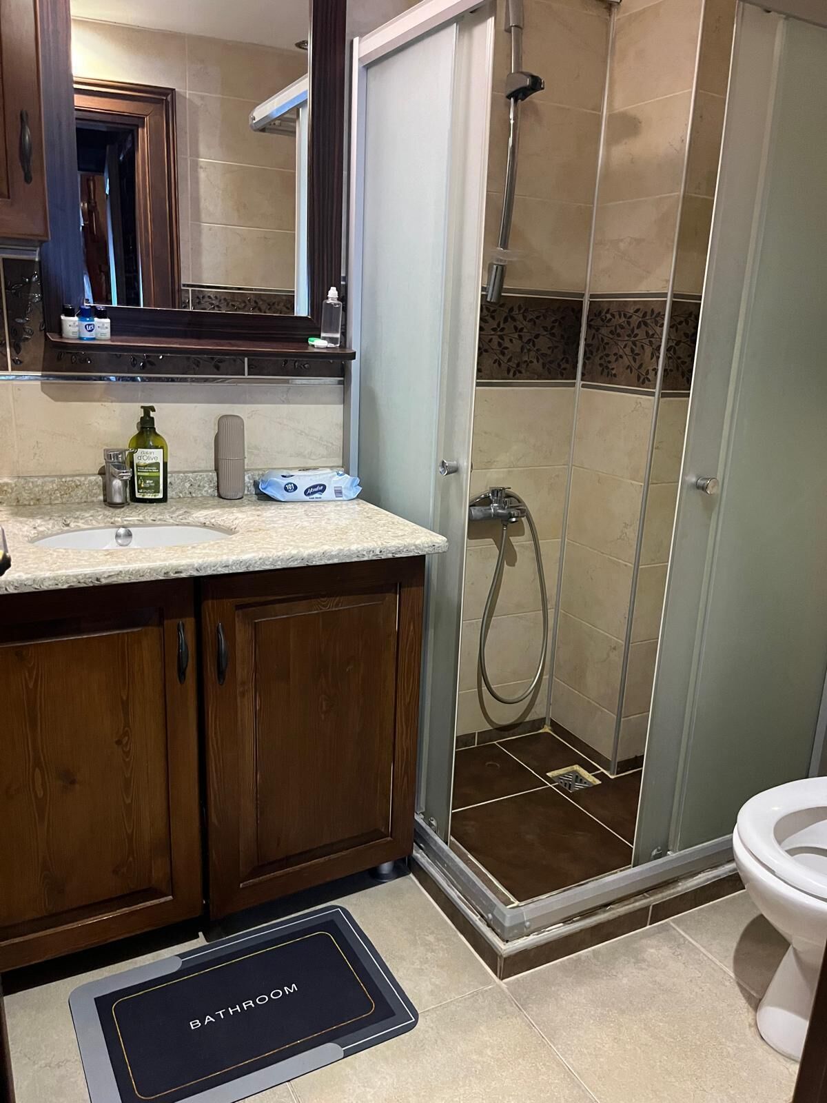 A bathroom with a shower, toilet, and sink.