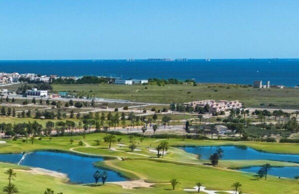 A golf course with multiple ponds and a coastal view. - La sunrise sea view and golf luxury apartment (los alcazares)
