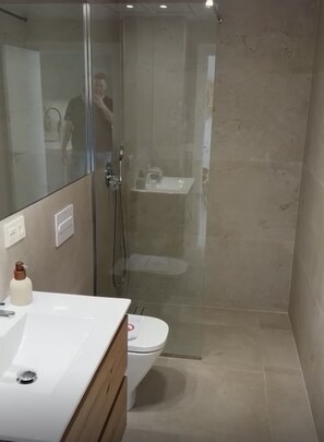 A modern bathroom with a glass-enclosed shower, a white sink, and a toilet. - La sunrise sea view and golf luxury apartment (los alcazares)
