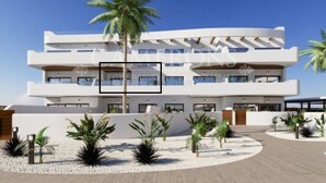 A modern multi-story hotel with a white facade, multiple balconies, and a landscaped courtyard with palm trees and shrubs. - La sunrise sea view and golf luxury apartment (los alcazares)