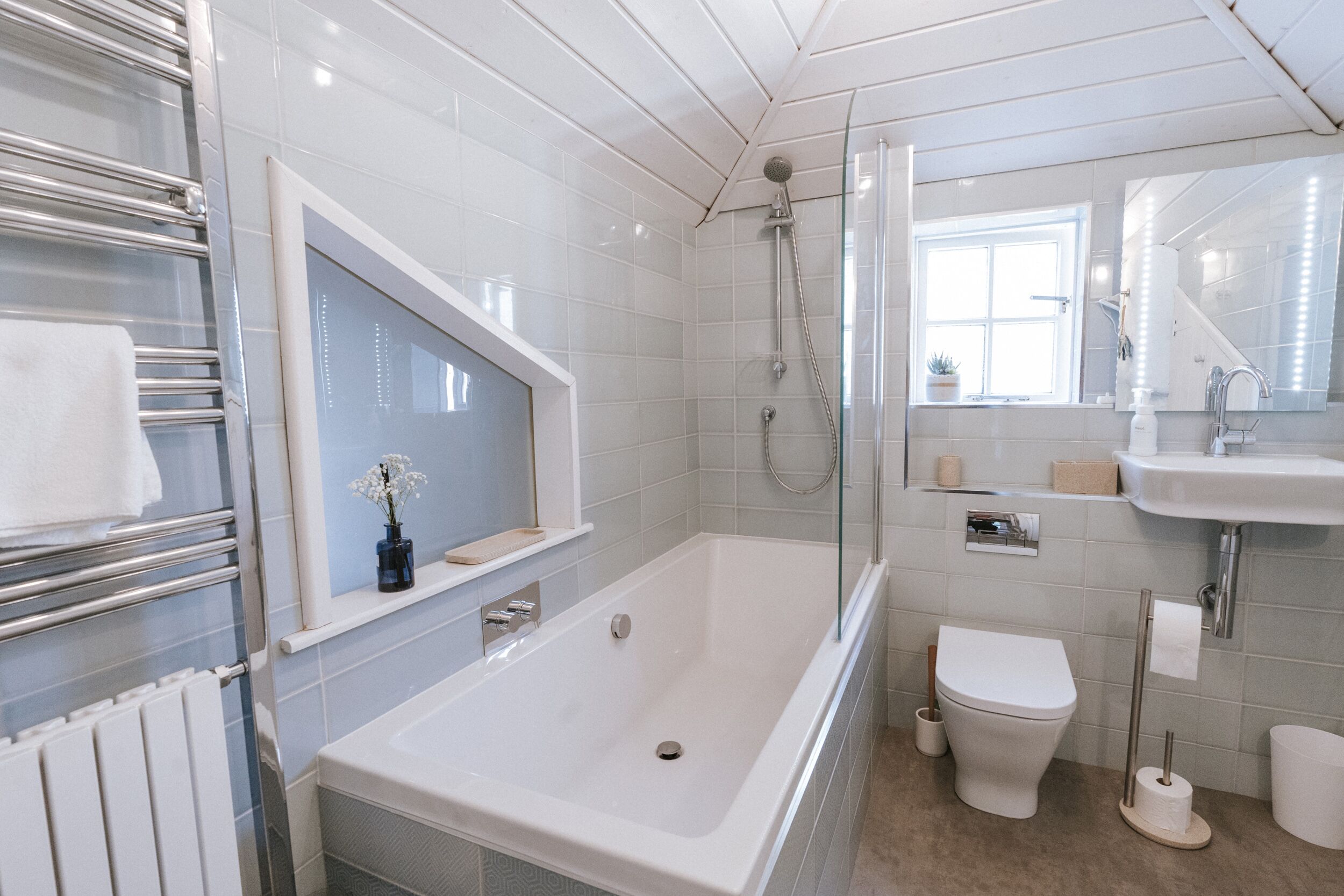 Een moderne badkamer met bad, toilet en wastafel.