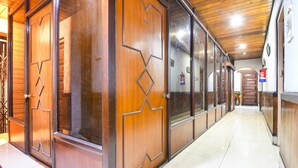 A hallway with wooden doors and a tiled floor. - Super Collection O Salt Lake (Bidhannagar)