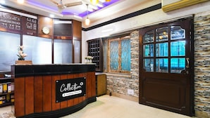 A reception desk with a sign reading 'Collection,' a clock, and a window with decorative metal grilles. - Super Collection O Salt Lake (Bidhannagar)