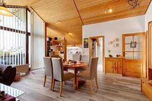 Un intérieur moderne comprenant un coin repas, une cuisine et un plafond en bois.