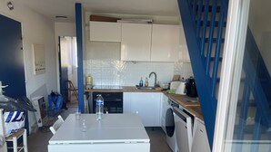 A compact kitchen with white cabinets, a central island, a sink, and a stove. - Carcans - 3 bedrooms near ocean + Parking (Carcans)