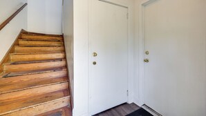 A wooden staircase leading to a white door with a doorknob. - Walk to Food & Art: Condo in Historic Riverside (Jacksonville)