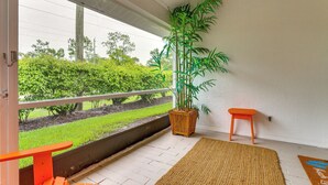 A balcony with a potted plant, a small orange stool, and a woven rug. - 5 Mi to Naples Beach - Getaway w/ Screened Lanai! (Naples)