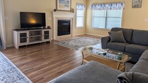 Una sala de estar con chimenea, televisor, sofá y una mesa de centro.