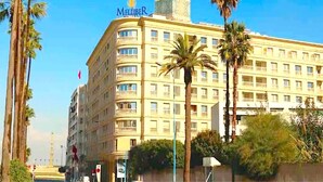 A large, multi-story hotel with a prominent tower and a sign reading "Mellibee". - Casa Sahifa (Casablanca)