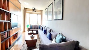A modern living room with a grey sectional sofa, a coffee table, and a bookshelf. - Casa Sahifa (Casablanca)