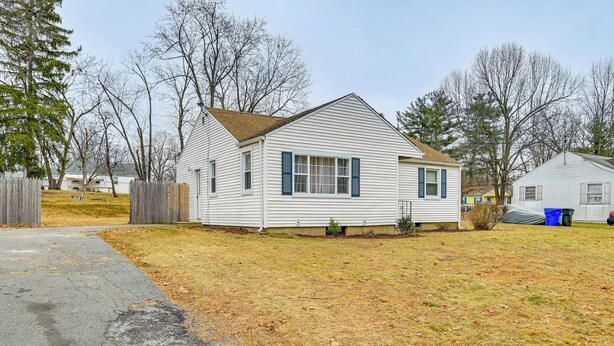 A single-story house with a front yard, a driveway, and a wooden fence. - Modern Home w/ Spacious Yard in Springfield! (Springfield)