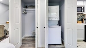 A laundry room with a washing machine and dryer, a shelf with laundry items, and a microwave in the adjacent kitchen area. - 1 Mi to Dtwn: Renovated Retreat in Georgetown! (Georgetown)