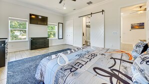 A bedroom with a bed, a ceiling fan, a dresser, and a window. - 'the Blue Oasis' Group Getaway! Walk to Jax Beach (Jacksonville Beach)