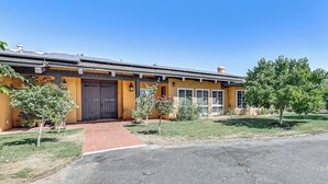 A two-story building with a yellow facade, a dark brown door, and a brick pathway leading to the entrance. - Stunning Valley & Mtn Views: Elegant Temecula Home (Temecula)