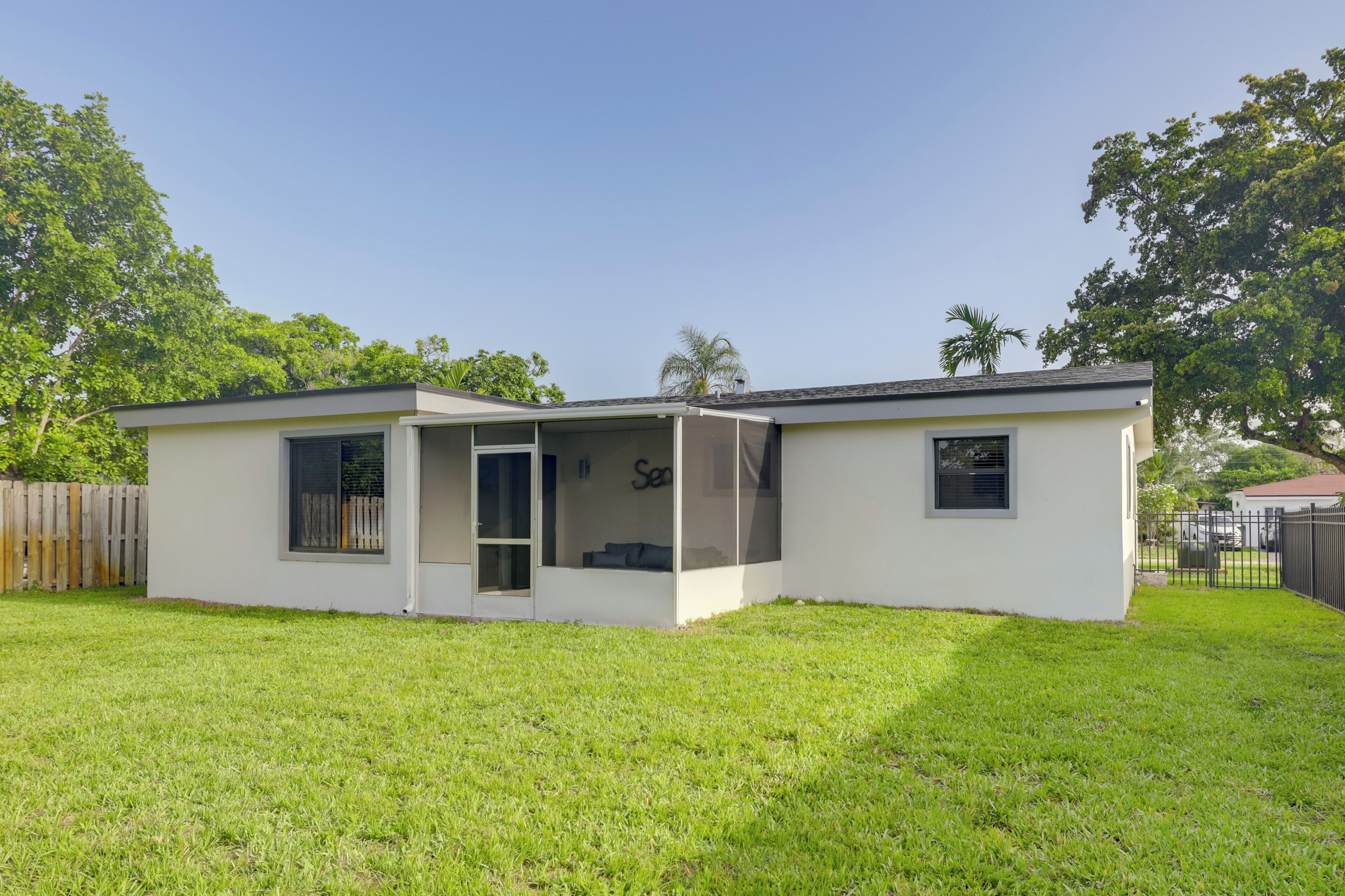 A modern single-story house with a covered patio, a garage, and a fenced backyard.