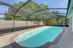A covered swimming pool with a wooden fence in the background.
