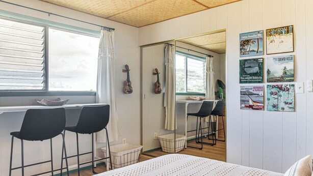 A room with a bed, a desk with two chairs, a window with blinds, and a wall with framed pictures. - 1 Mi to Town & Rainbow Falls: Updated Hilo Getaway (Hilo)