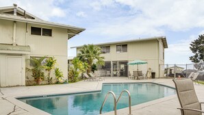 A swimming pool with a metal ladder, lounge chairs, and a covered seating area with an umbrella. - 1 Mi to Town & Rainbow Falls: Updated Hilo Getaway (Hilo)